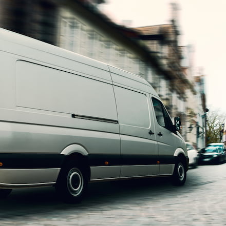 a sprinter van turns a corner and drives away