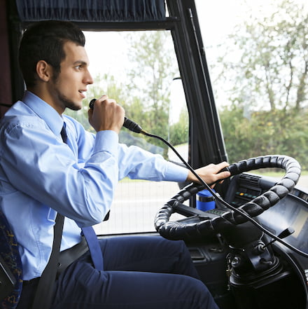 a bus driver uses an onboard mic to make an announcement